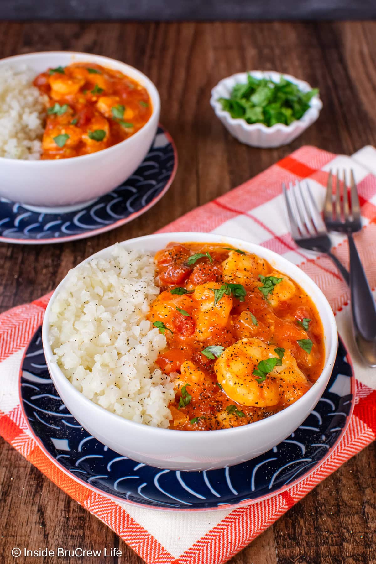 Two white bowls filled with rice and shrimp curry.