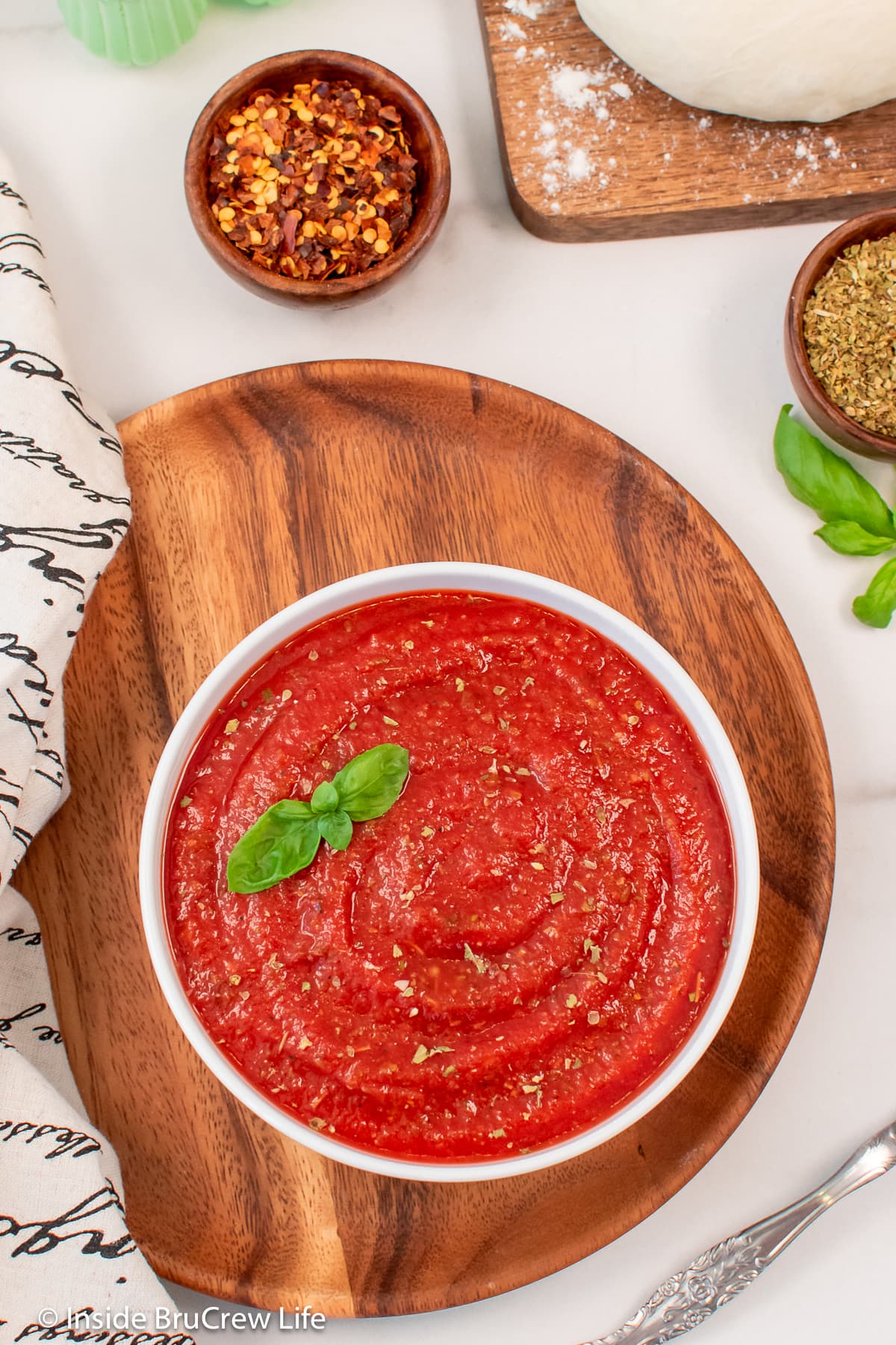 Overhead picture of a bowl of red sauce on a tray.