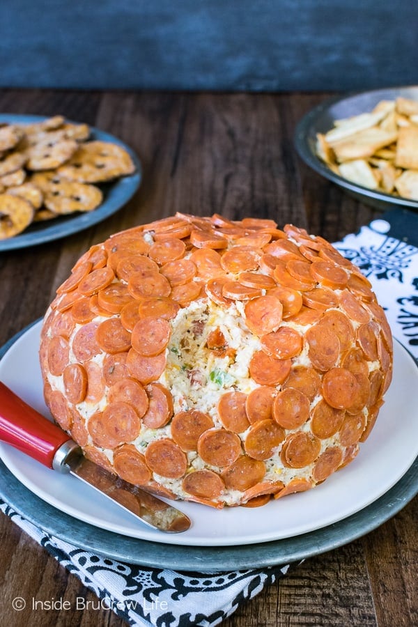 A cheese ball loaded with pizza toppings and covered in mini pepperonis.