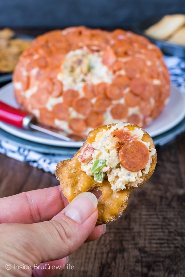 A thin pretzel crisp with a pizza cheese ball on it.