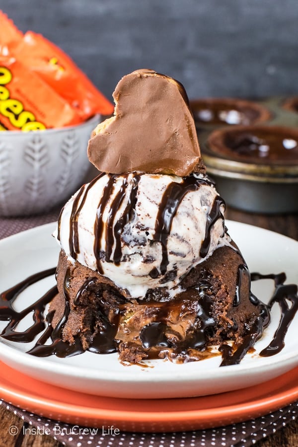 Chocolate lava cake topped with ice cream, chocolate syrup and a reese's heart.