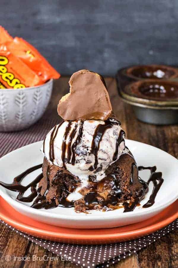 Chocolate lava cake topped with ice cream, chocolate syrup and a reese's heart.