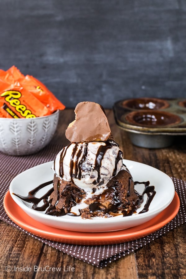 Chocolate lava cake topped with ice cream, chocolate syrup and a reese's heart.