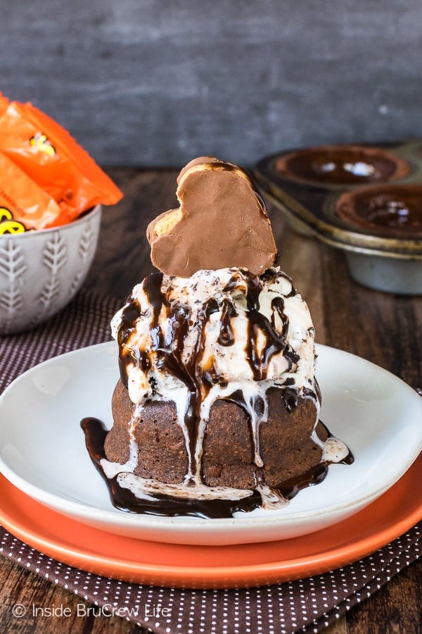 Chocolate lava cake topped with ice cream, chocolate syrup and a reese's heart.