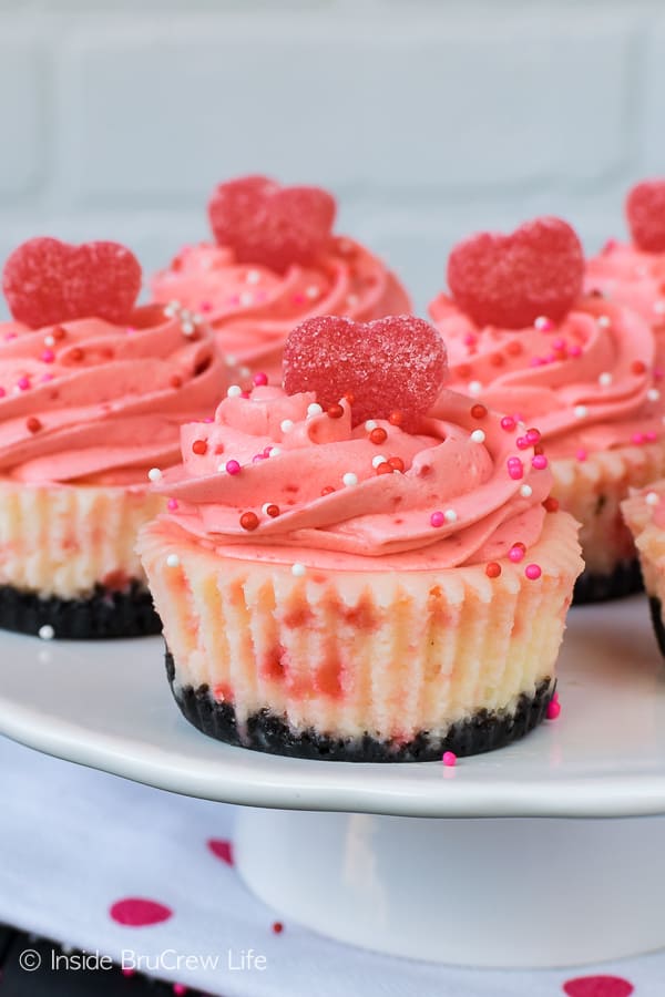 Red Hot White Chocolate Cheesecakes with jelly cinnamon hearts and sprinkles on a white cake plate