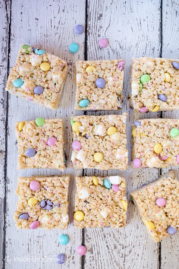 Overhead picture of a white board with rice krispie treats with M&Ms and sprinkles on it