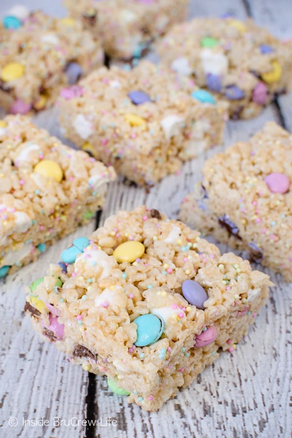 A white board with rice krispie treats with M&Ms and sprinkles on top of it