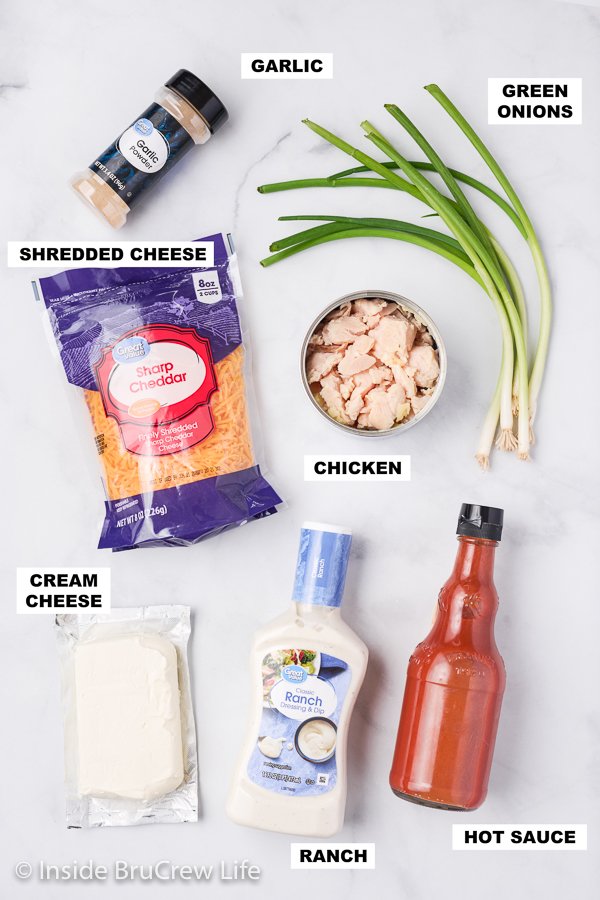 A white board with ingredients needed to make a buffalo chicken dip.