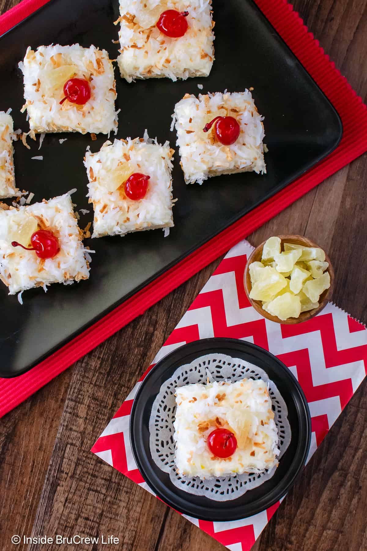 An overhead picture of pina colada bars on two black plates.