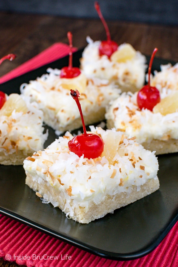 Pina Colada Sugar Cookie Bars - these easy cookie bars are made and frosted in one pan. Coconut and pineapple add a fun tropical flair to the cookie bars. Make this easy recipe for parties or summer picnics. #sugarcookiebars #easy #dessert #frosting #pinacolada #pineapple #coconut #barcookies #bakesale