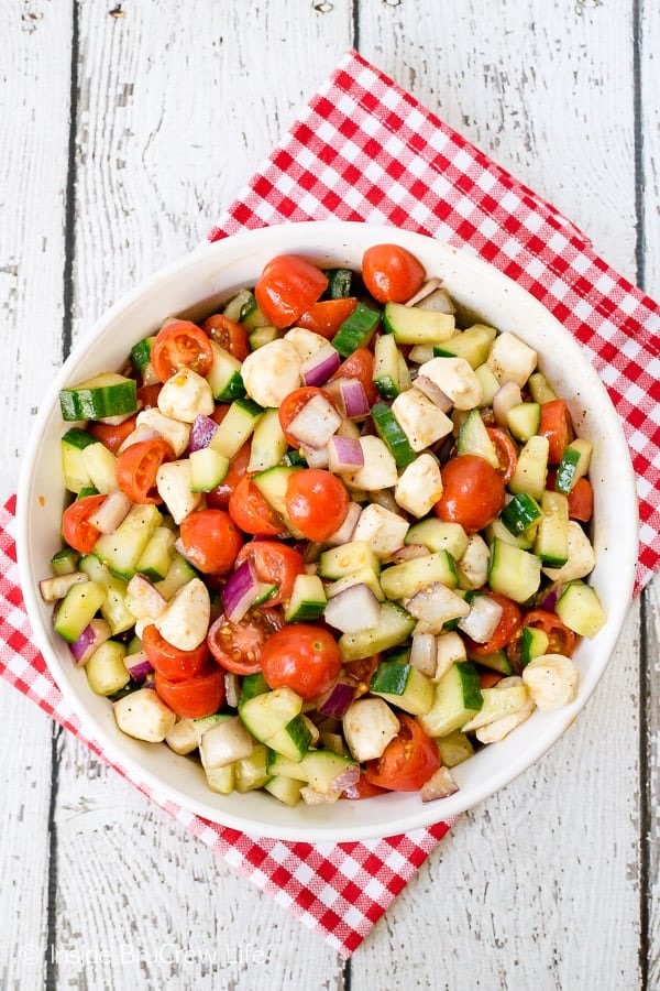 Balsamic Caprese Veggie Salad - a big bowl of this easy veggie salad is the perfect side dish to make for any meal. Try this healthy recipe all summer long. #salad #healthy #tomatoes #cucumber #picnic #sidedish #veggies #leanandgreen