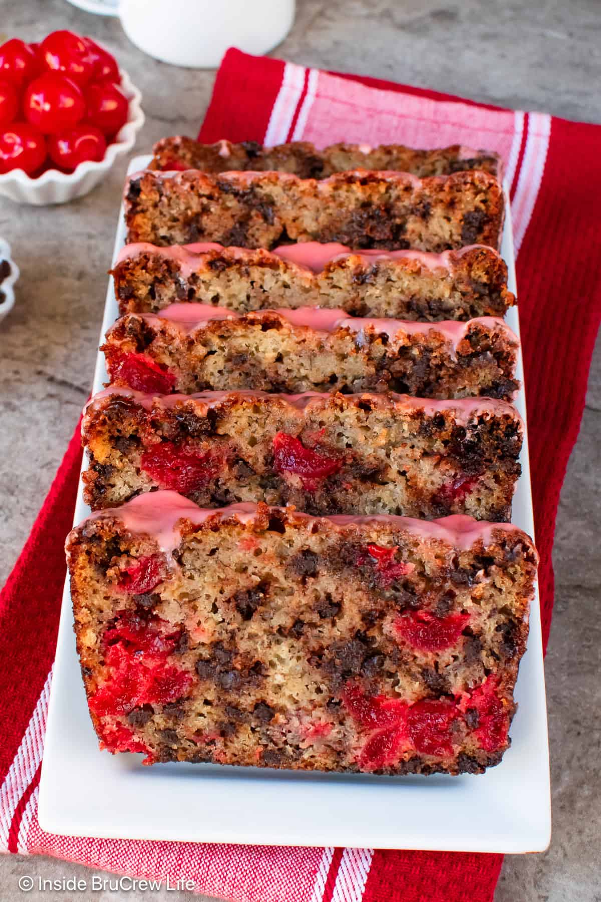 Slices of cherry banana bread with chocolate chips on a white plate.