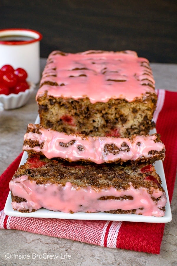 Slices of glazed cherry banana bread with chocolate chips on a white plate.