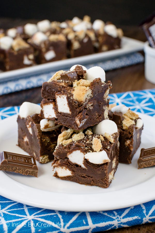 A white plate with squares of chocolate marshmallow fudge on it.