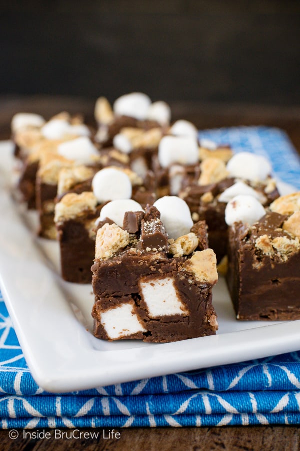 A white plate with squares of chocolate marshmallow fudge on it.