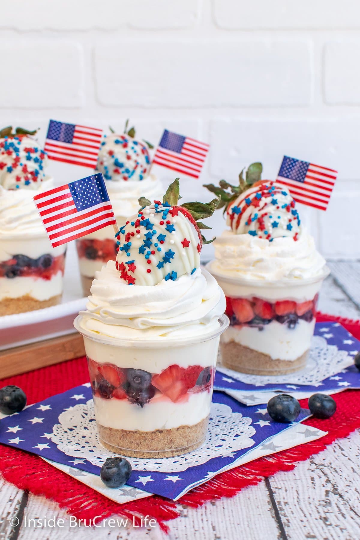 Cheesecake cups with red and blue fruit and flags.