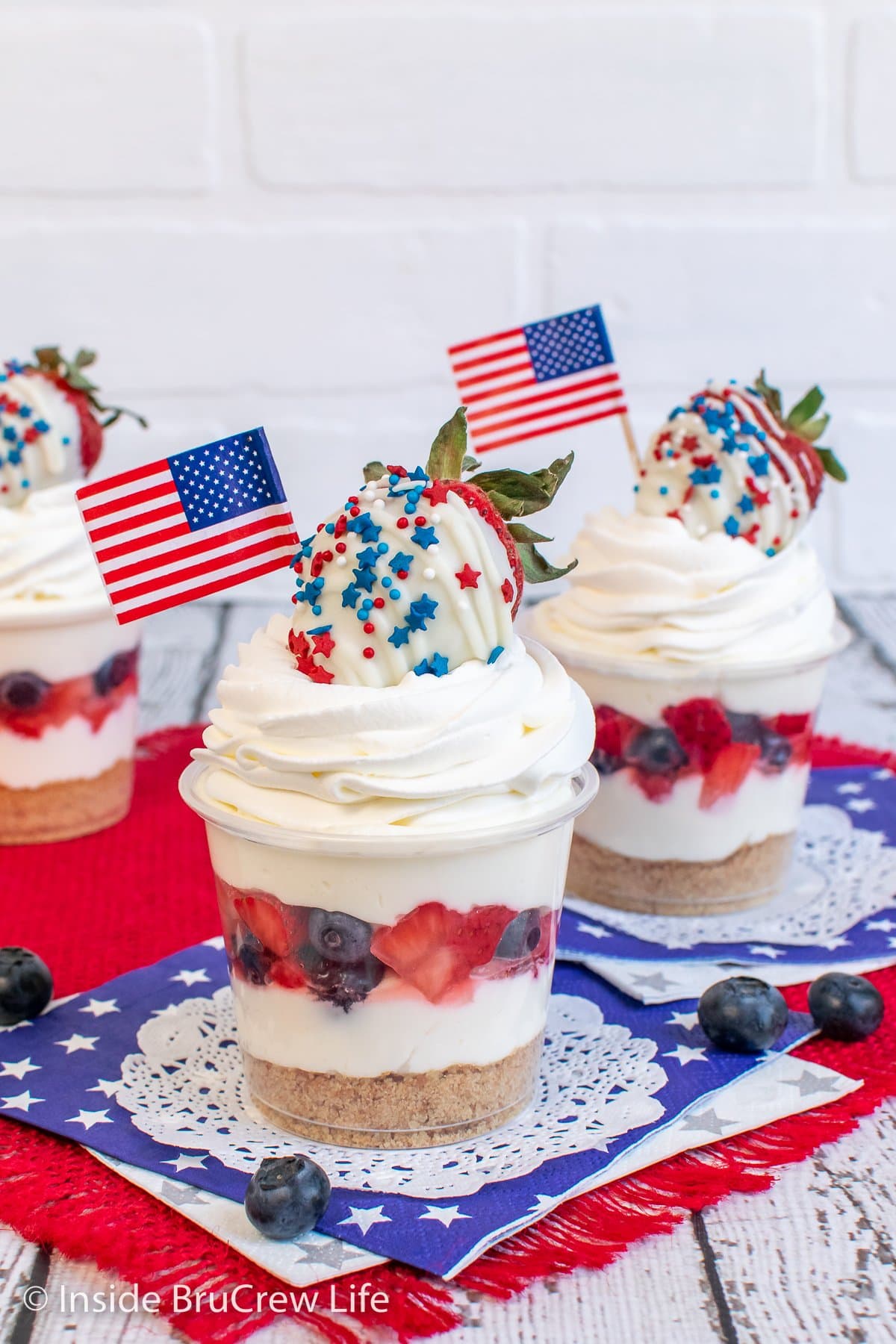 Cheesecake cups with red and blue fruit and flags.