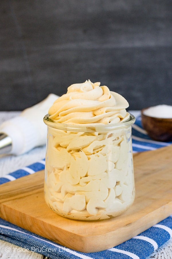 A clear jar filled with a swirl of salted caramel icing in it.