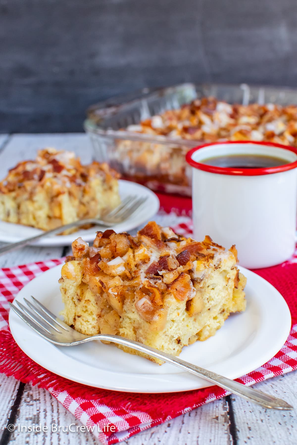 Two white plates with squares of breakfast casserole on them.