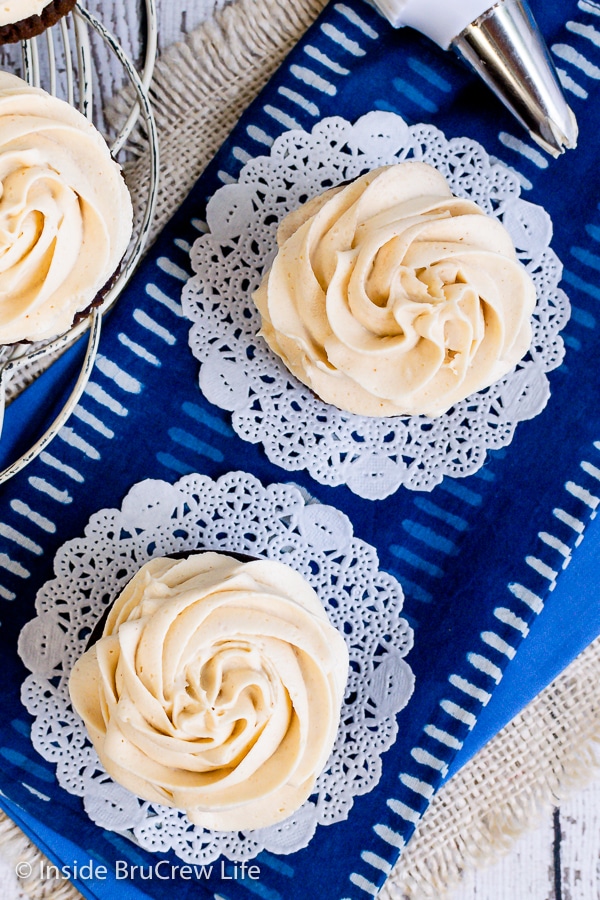 Overhead picture of cupcakes on a blue towel with swirls of peanut butter buttercream icing on them.