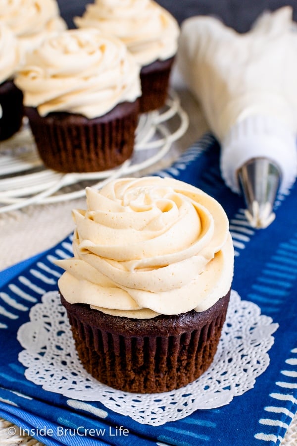 A chocolate cupcake on a blue towel with a swirl of peanut butter icing on top.