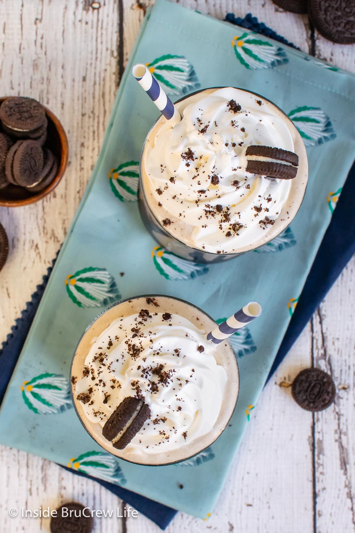 Overhead picture of two milkshakes topped with Cool Whip and Oreos.