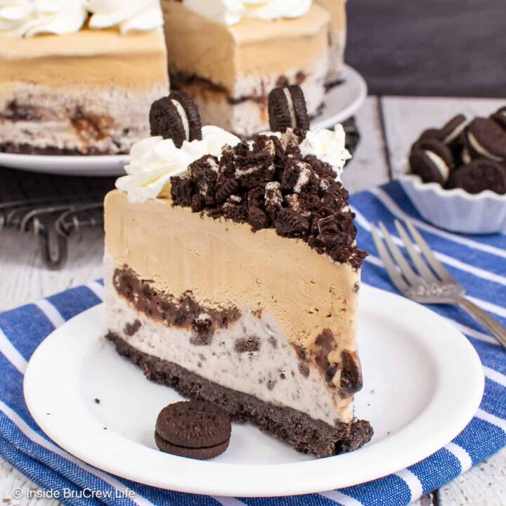 A slice of coffee ice cream cake with an Oreo crust and a layer of cookies and cream ice cream.