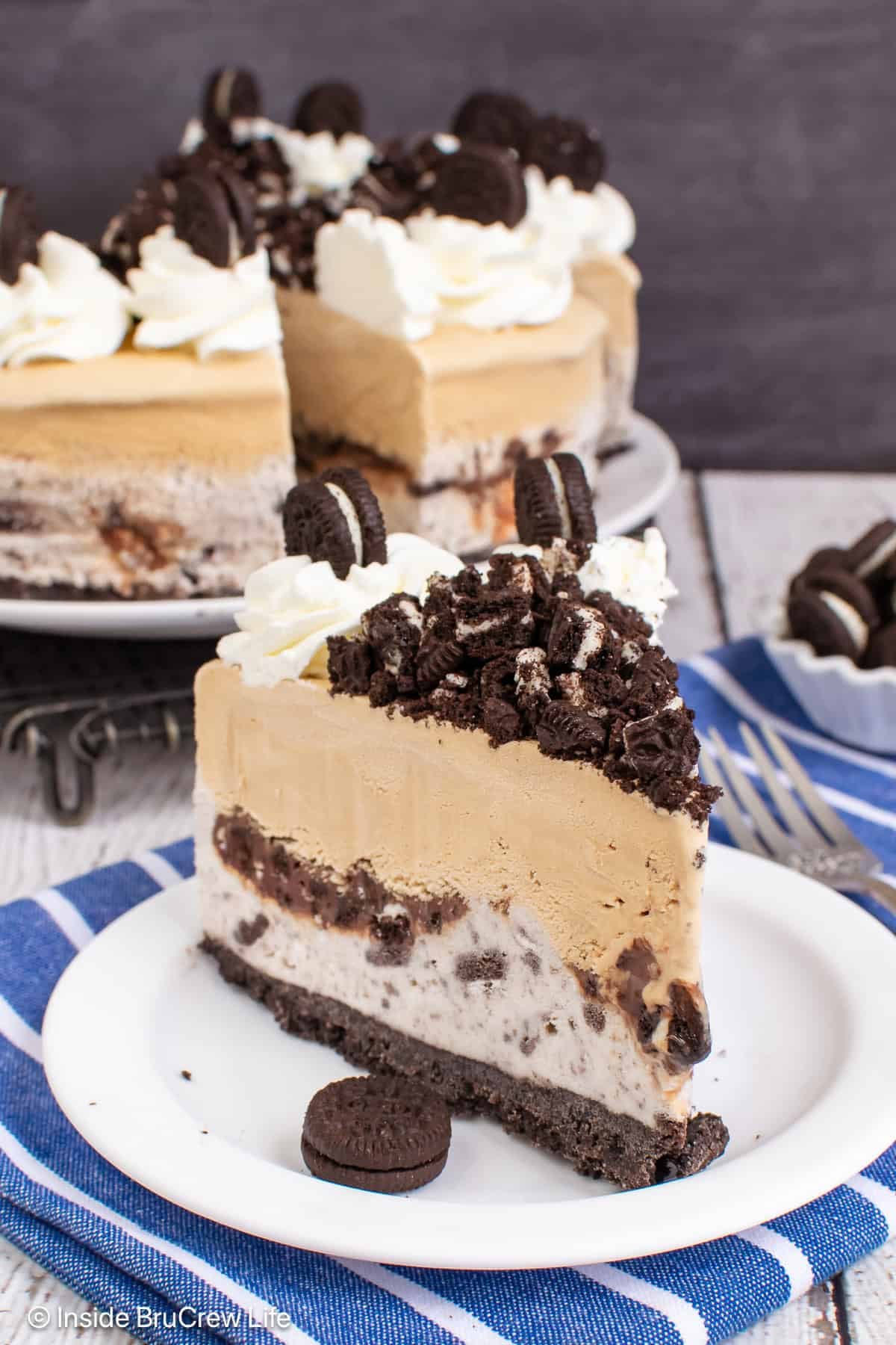 A slice of coffee ice cream cake with an Oreo crust and a layer of cookies and cream ice cream.