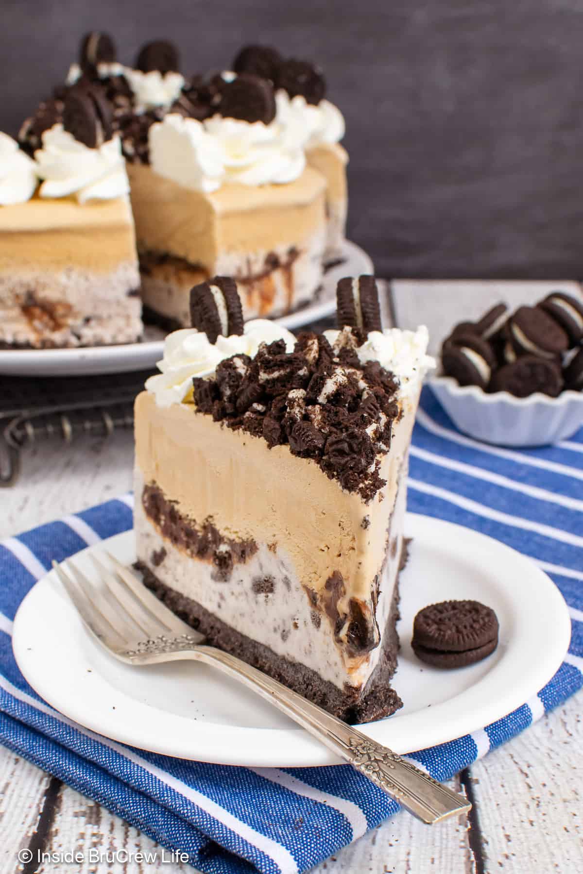 A layered cookies and cream coffee ice cream cake slice on a plate.