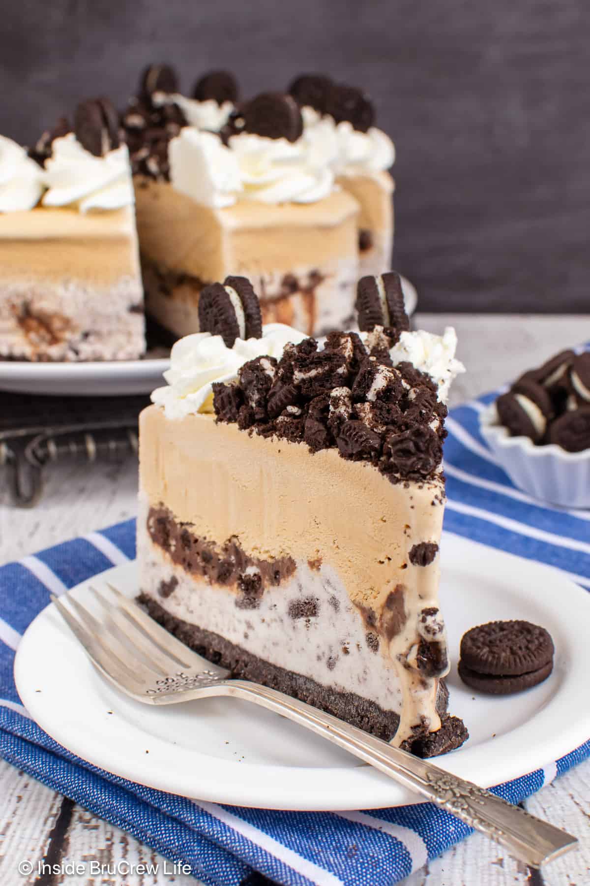 A white plate with a slice of coffee ice cream cake with Oreos.