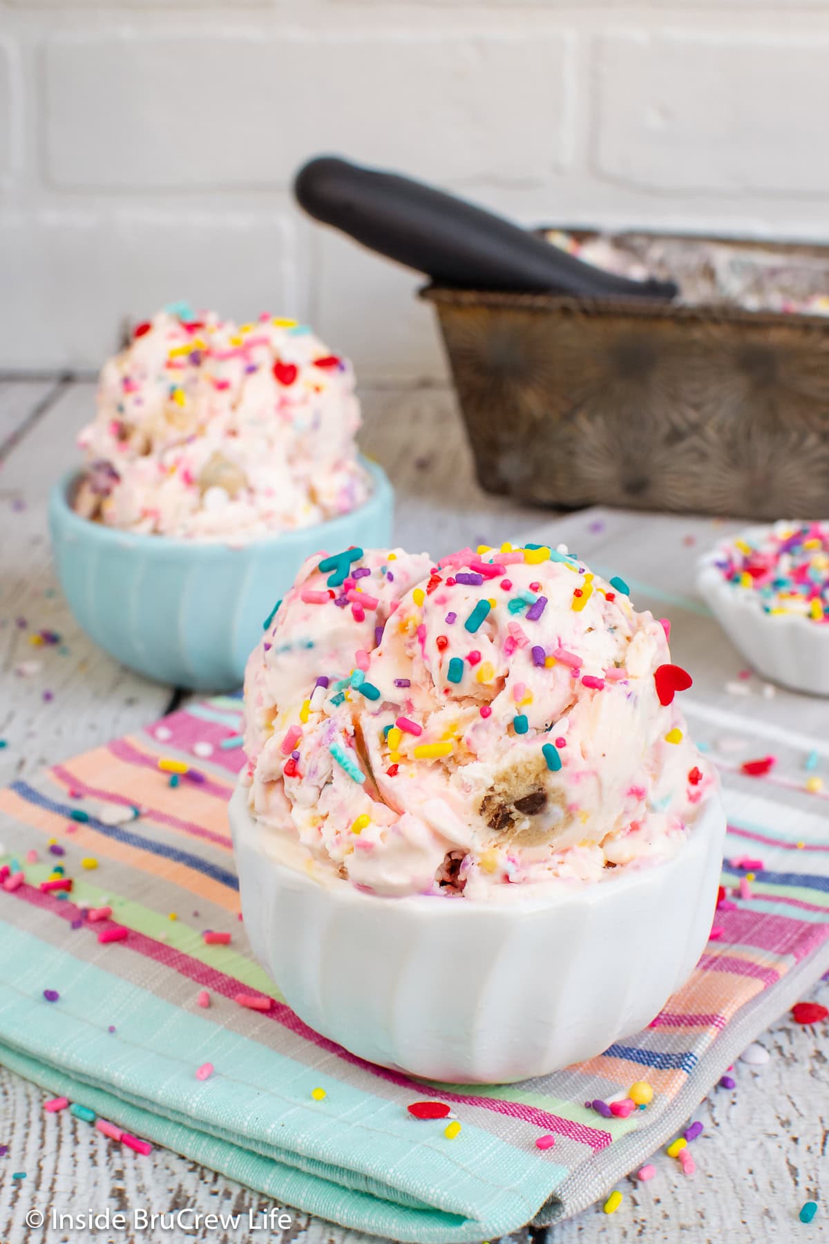 Two bowls of cookie dough ice cream loaded with sprinkles.