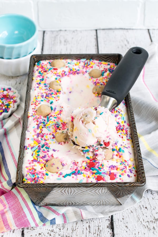 A pan of ice cream with an ice cream scoop in it.