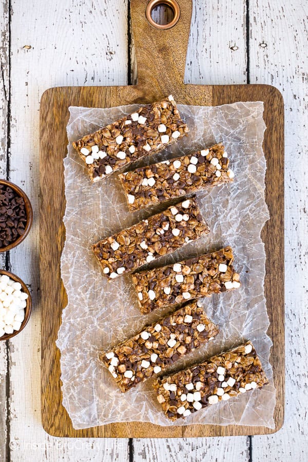 An overhead picture of a wooden cutting board with a row of nutella s'mores granola bars lined up on it