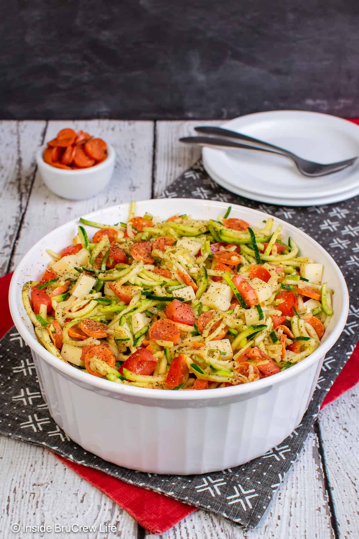 A white bowl filled with pizza zucchini salad.