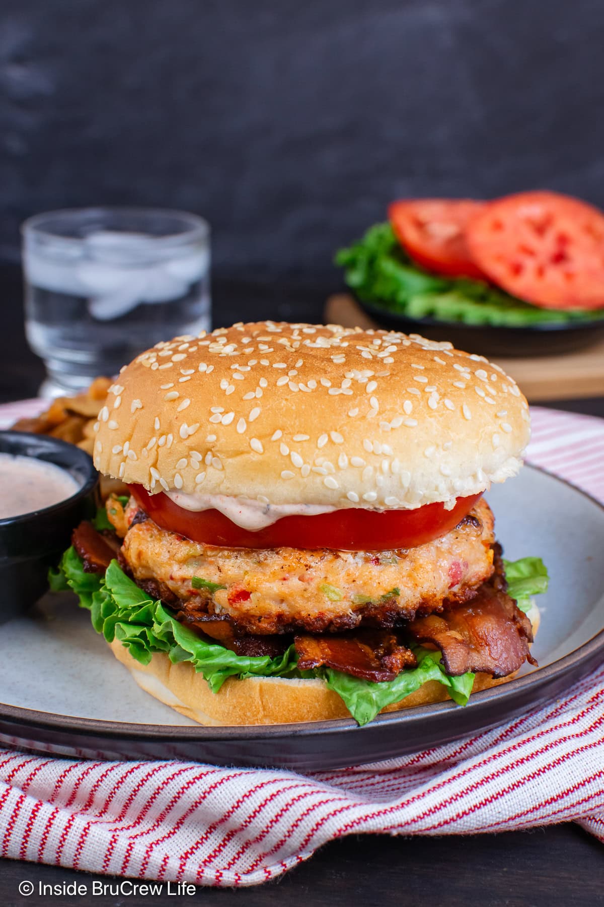 Lettuce, tomato, and bacon on a shrimp burger.