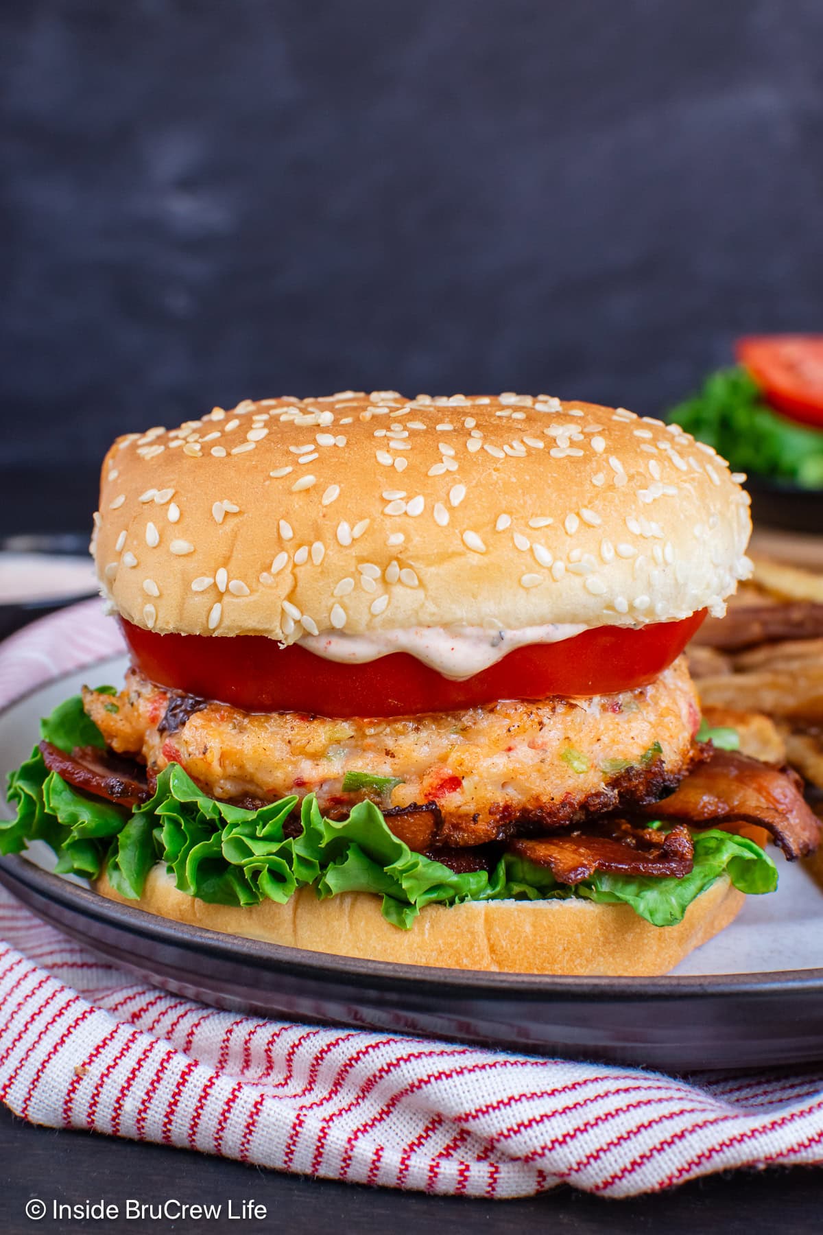 A bun with a patty and lettuce and tomato on it.