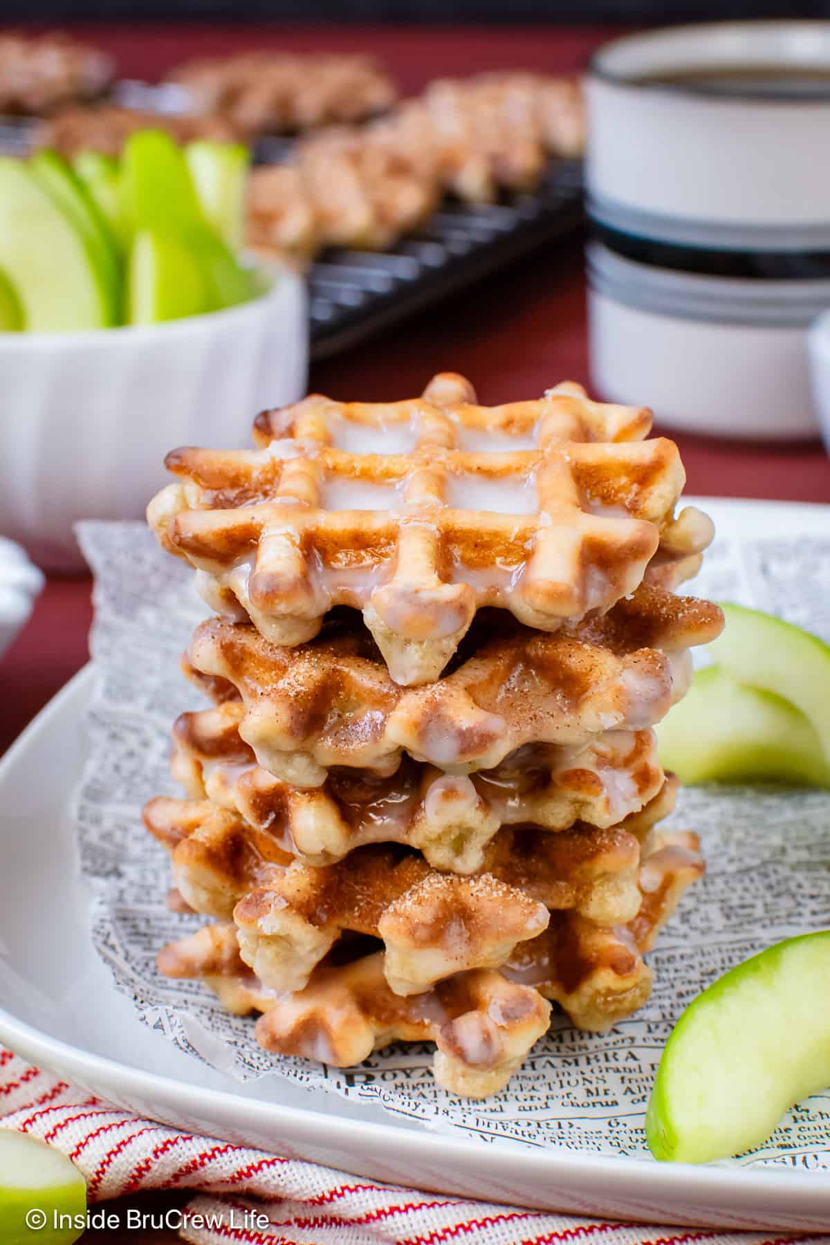 A stack of apple fritter waffles on a plate.