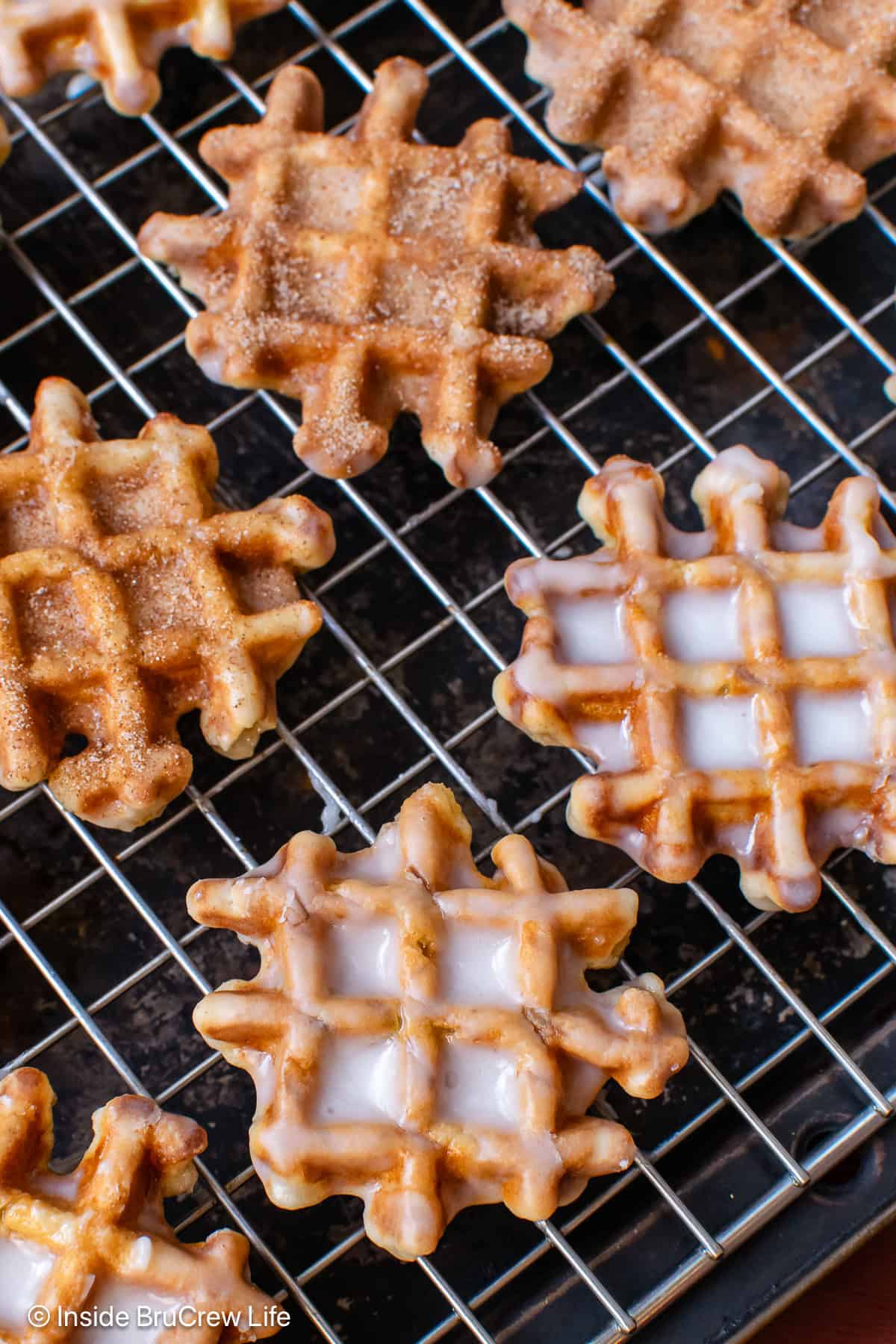 A cooling rack with glazed waffle donuts on it.