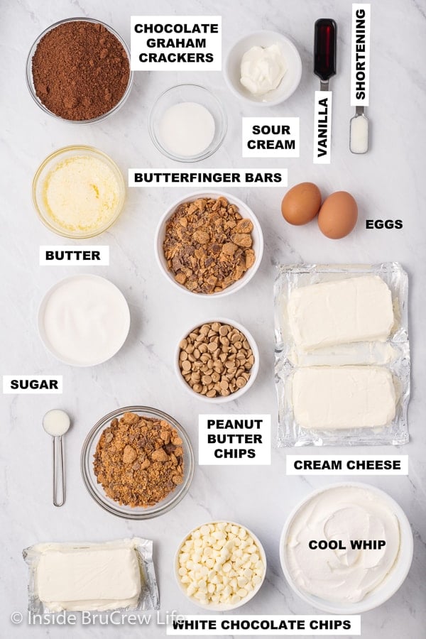 A white board with bowls of ingredients needed to make mini cheesecakes.