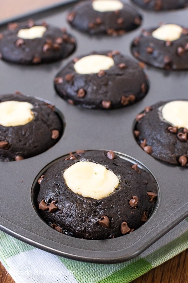 Chocolate Zucchini Muffins with cheesecake centers in a gray muffin tin