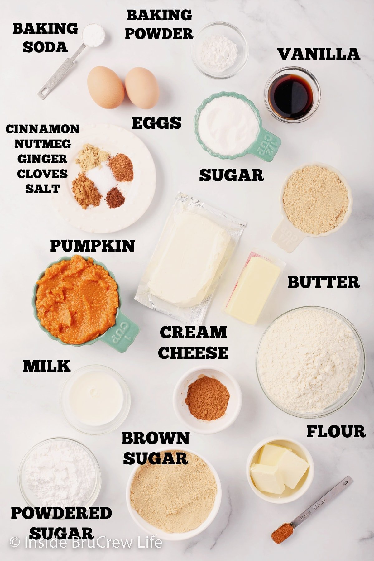 A white board with bowls of ingredients to make a pumpkin coffee cake on it.