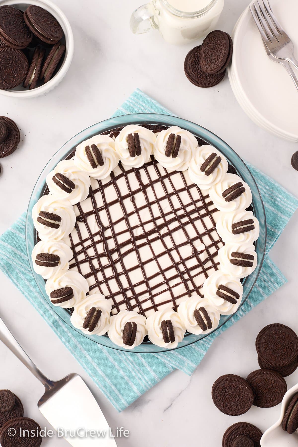 Overhead picture of an Oreo pie topped with fudge and cookies.