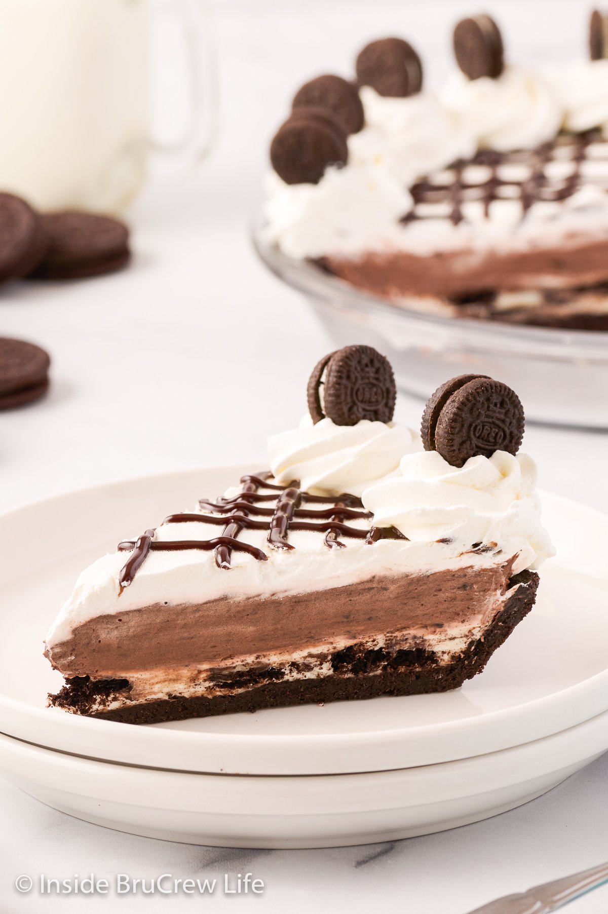 A slice of cookies and cream pie on a white plate.