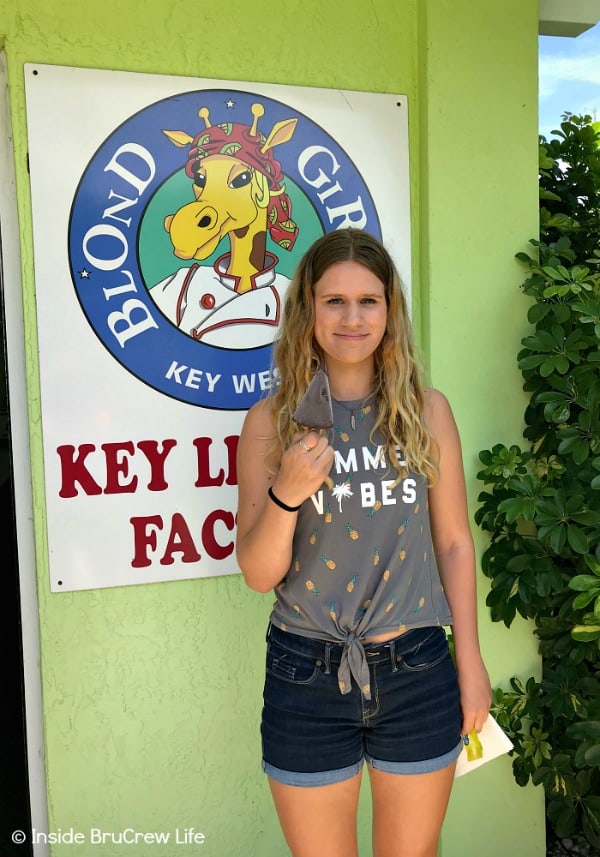 A girl holding a slice of pie from the Blond Giraffe Key Lime Pie Factory. 