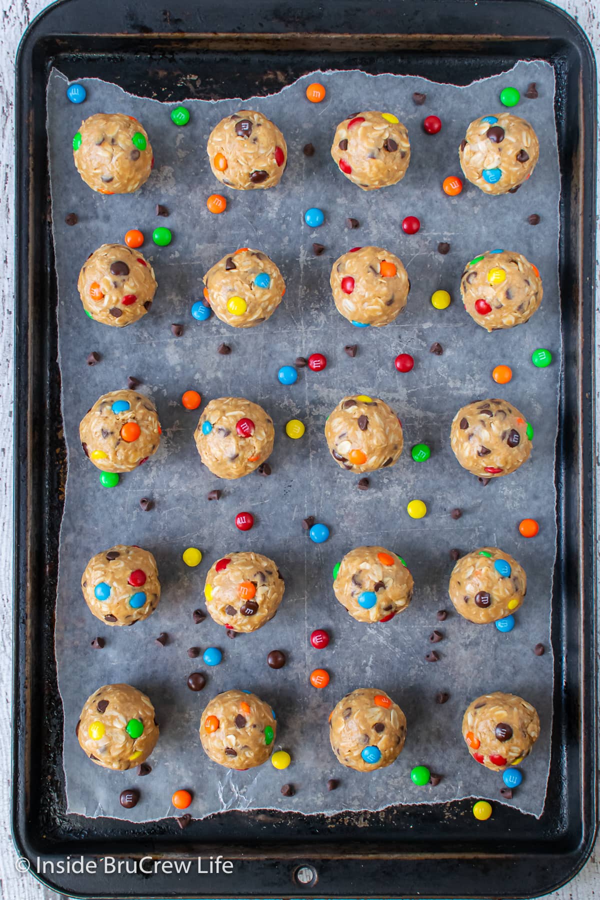 A sheet pan with cookie dough balls on it.