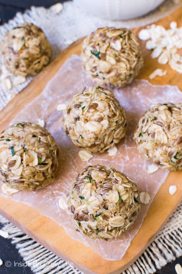 Overhead picture of zucchini oatmeal bites on a wooden tray with scattered oats