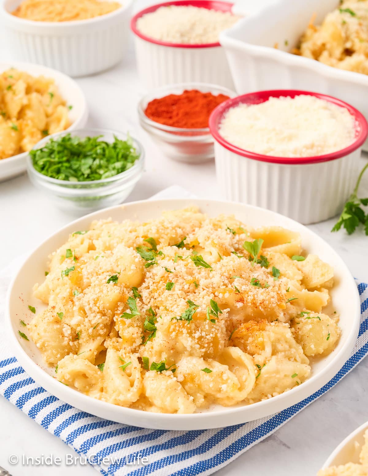 A white plate filled with mac and cheese topped with crumbs.