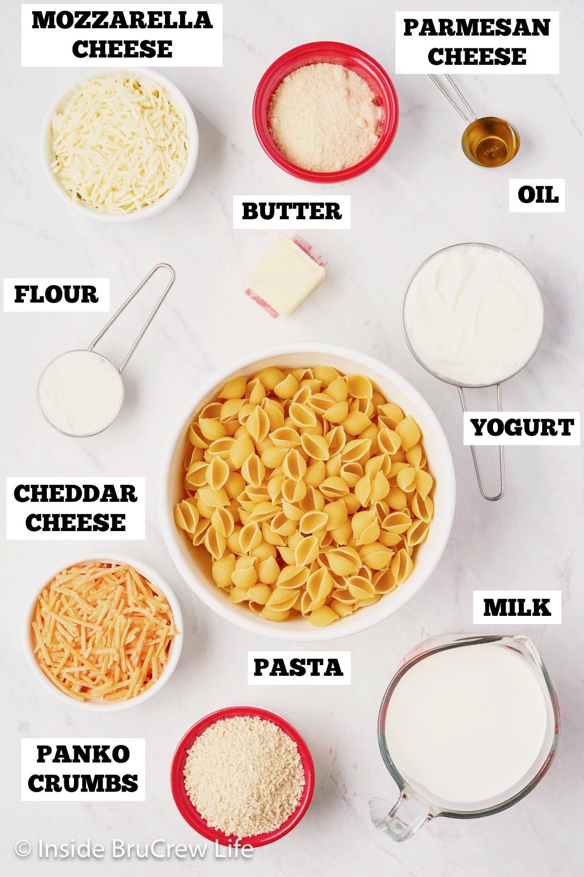 A white board with bowls of ingredients to make a baked pasta dinner.