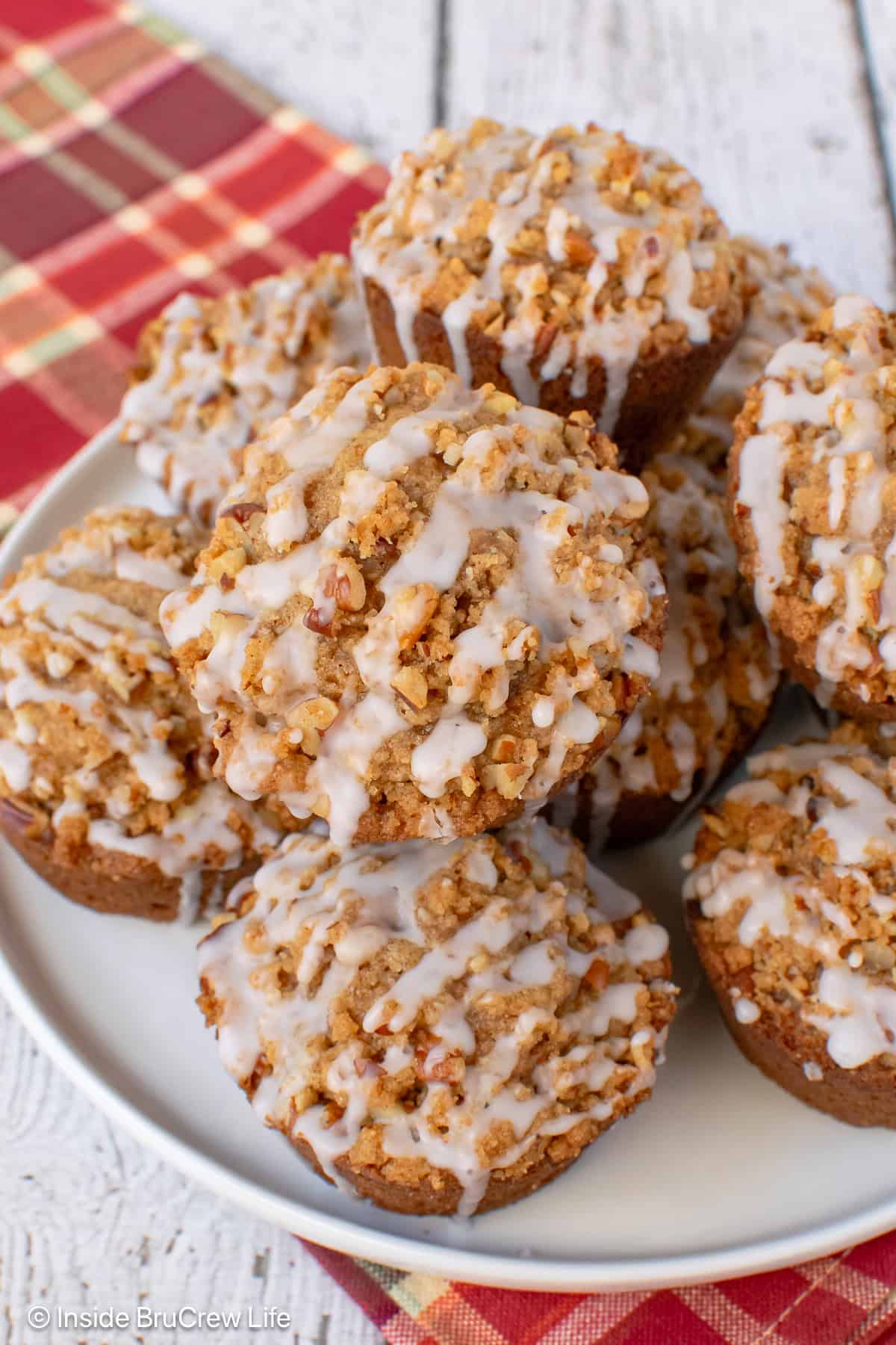 Streusel muffins piled on a white plate.