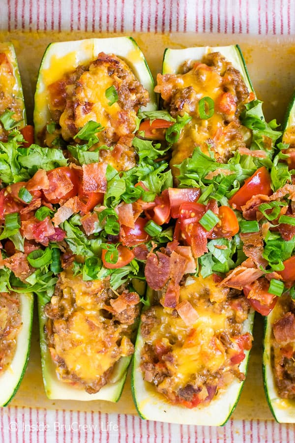 Overhead picture of stuffed zucchinis with cheeseburger filling in a baking dish.